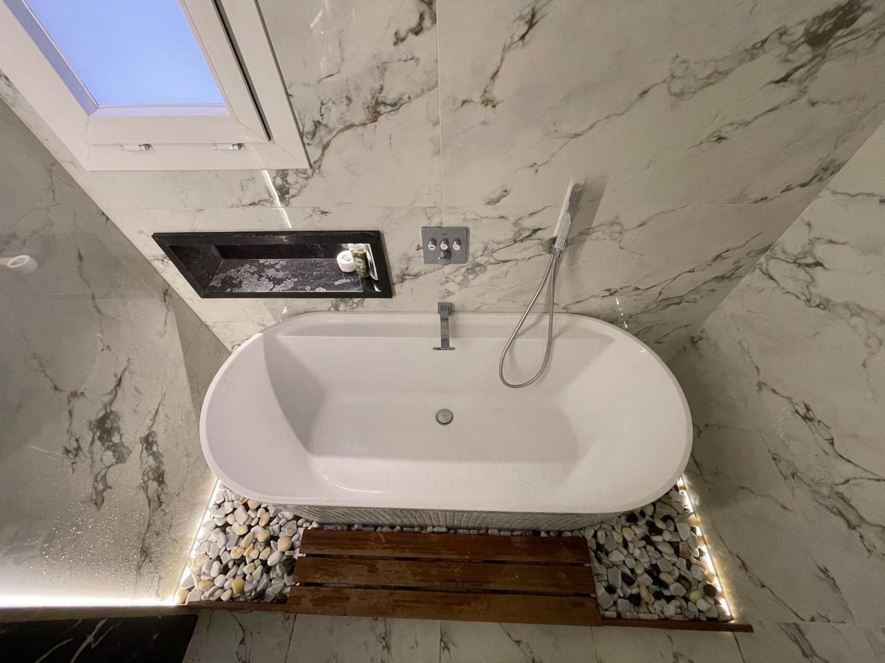 Bright Interiors finishing work: bathroom tub pebbles