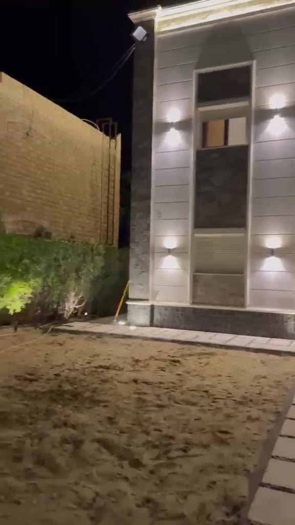 Renovated villa exterior with new cladding and lighting at night